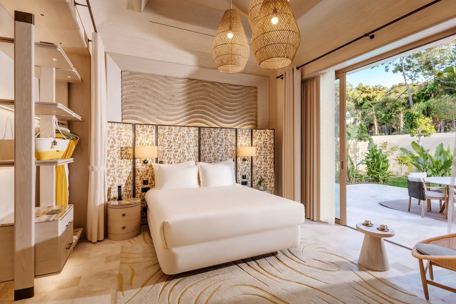 A bedroom with a large bed and a sliding glass door leading to a patio.